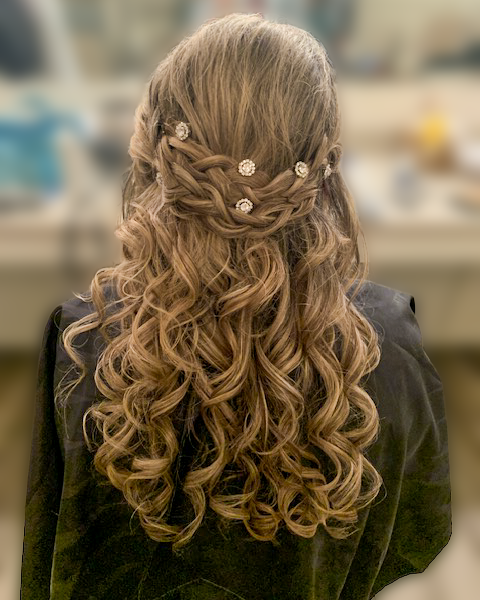 Long curled hair in a jeweled half-up occasion style at Maison de Cheveux.