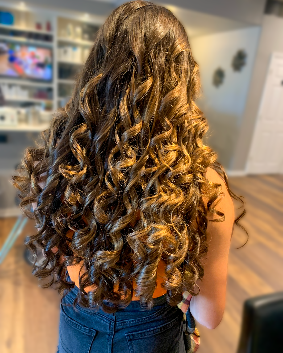 Long brunette hair styled in defined formal curls at Maison de Cheveux.