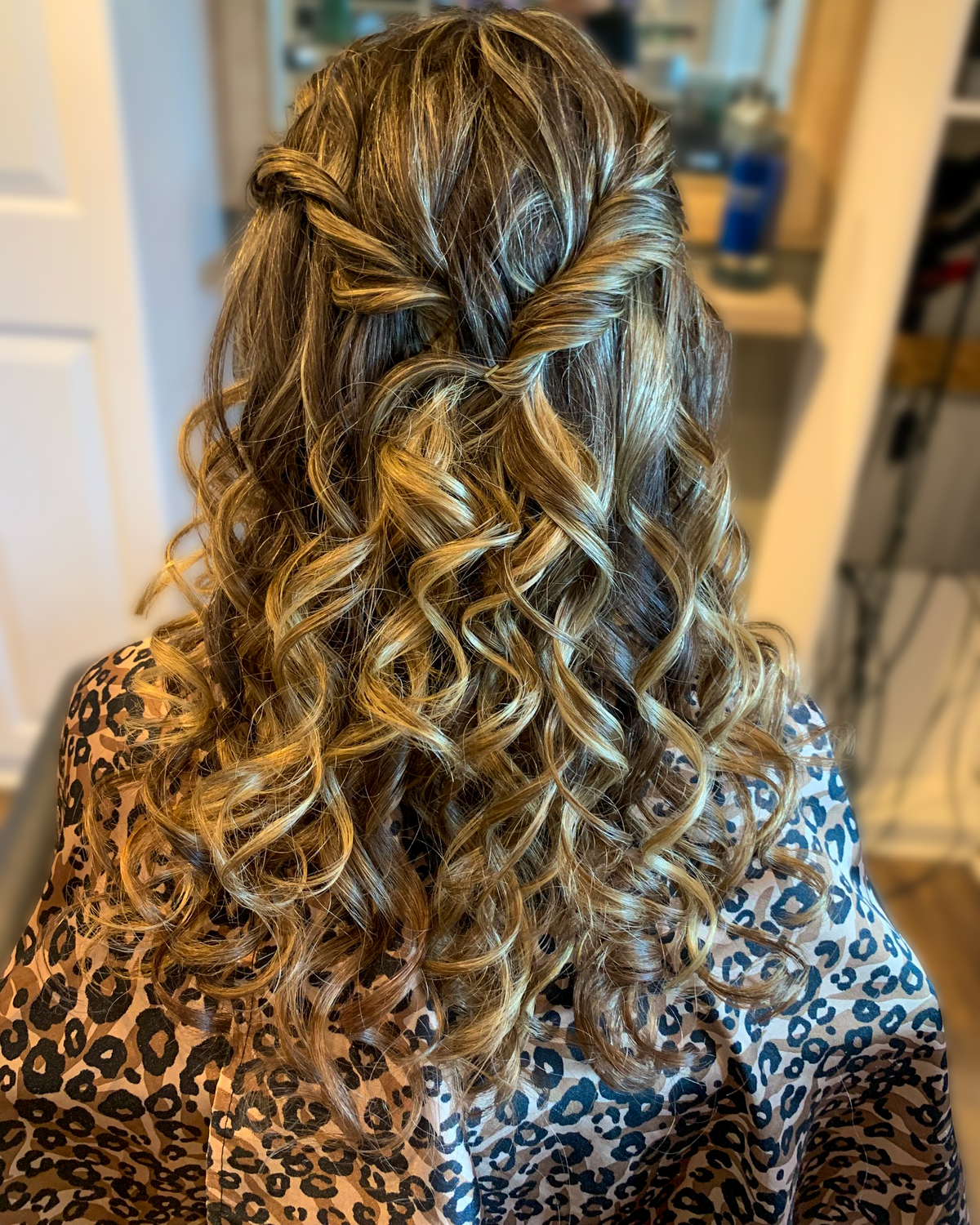 Highlighted hair styled in a soft half-up curl set at Maison de Cheveux.