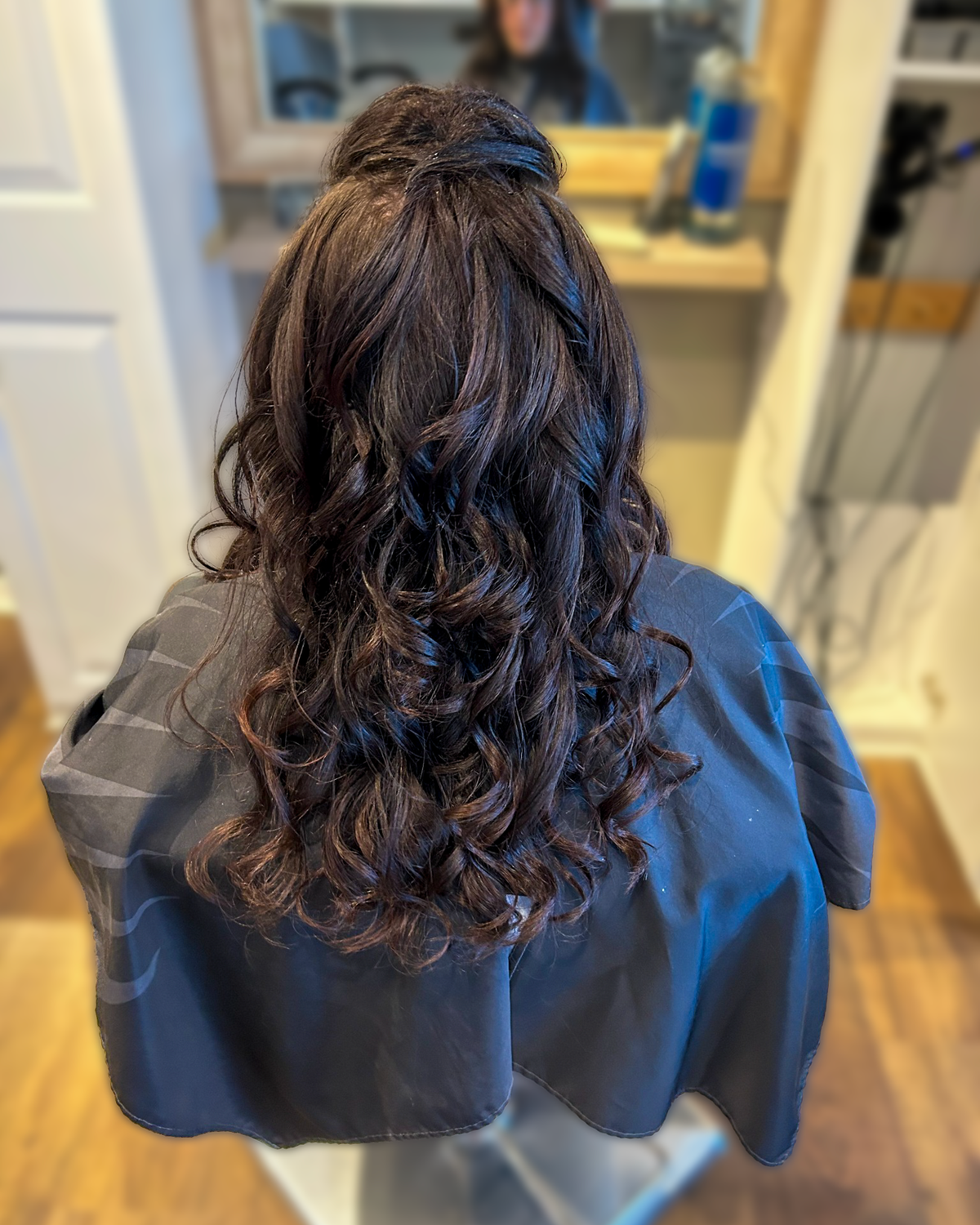 Dark brunette hair with a half-up curled finish at Maison de Cheveux.