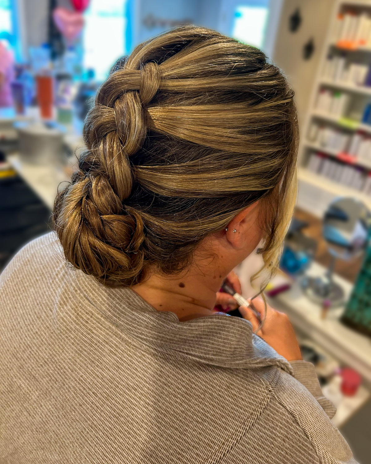 Dimensional brown hair styled in a braided updo at Maison de Cheveux.